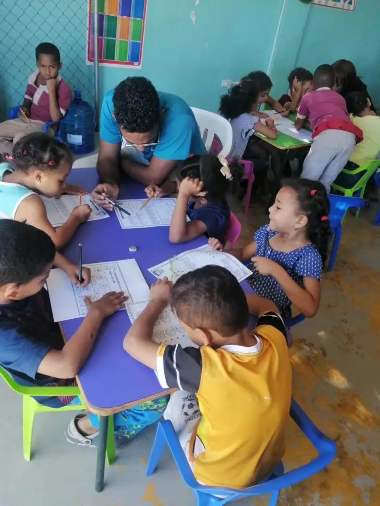 Children engaged in an interactive classroom activity with a teacher.