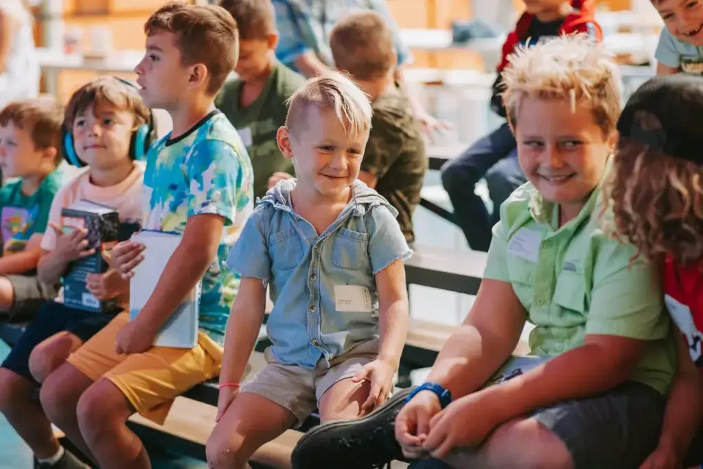 Children sitting together, smiling, in casual clothes.