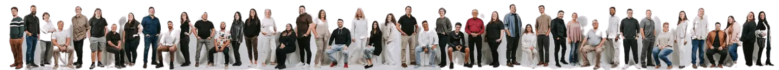 many people from the worship team sitting side by side in a photo studio pose.