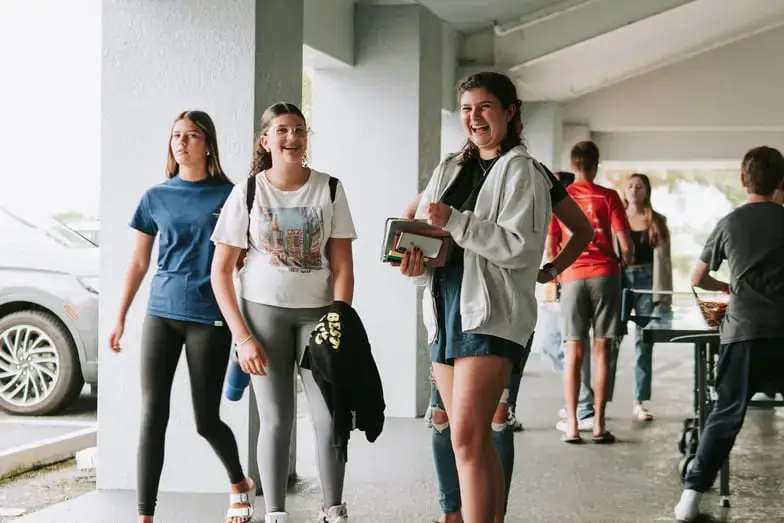 Group of young people walking in a modern hallway.
